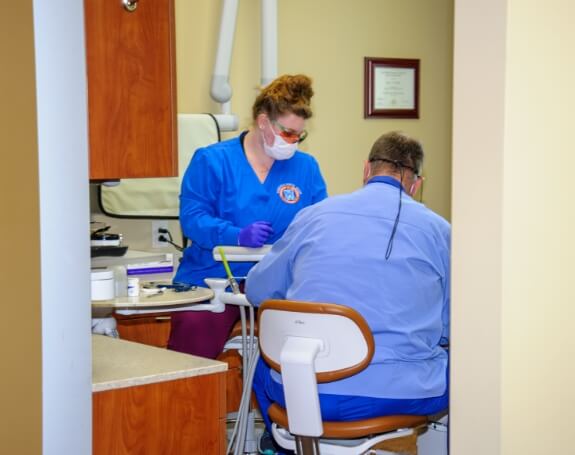 Dentist and dental team member treating patient