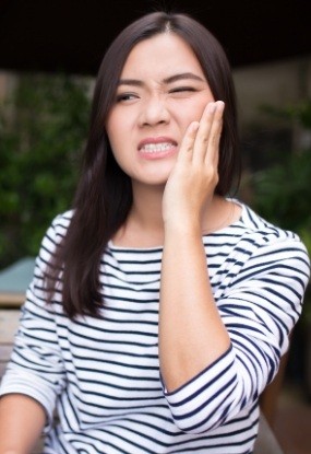 Woman in need of emergency dentistry holding jaw in pain