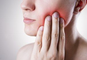 Patient with toothache holding jaw in pain