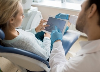 Dentist and patient looking at digital x-rays on tablet computer