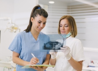 Dentist and dental team member reviewing x-rays