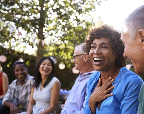 Woman laughing with friends enjoying the benefits of dental implants