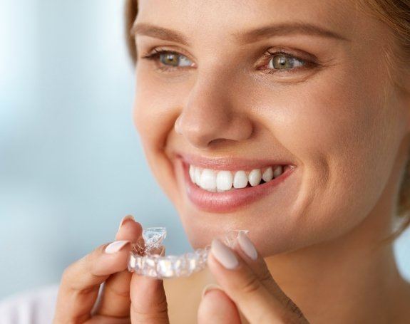 Woman placing an Invisalign tray