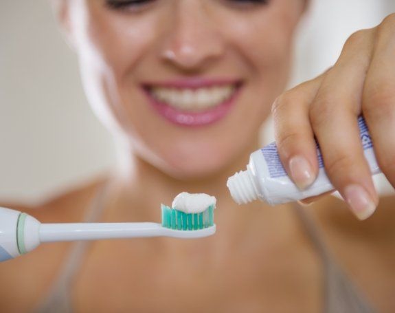 Patient using at home dental hygiene products