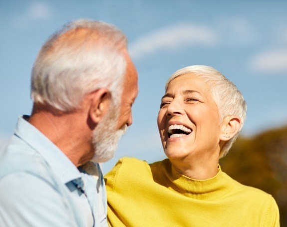 Man and woman smiling after tooth colored filling restoration