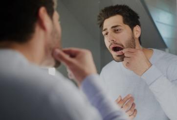 Man in need of restorative dentistry looking at his teeth