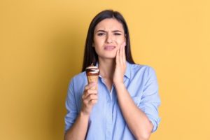 woman experiencing tooth sensitivity from ice cream
