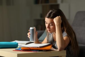 person studying and drinking an energy drink