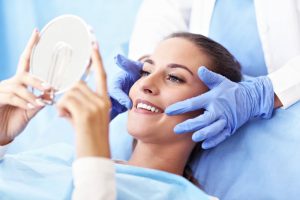woman admiring her new smile after getting cosmetic dentistry