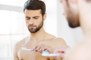 Man staring at toothbrush