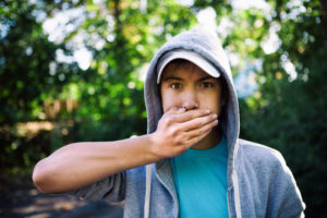 Teenage boy holding mouth