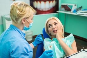 Woman with a chipped tooth visiting her emergency dentist.